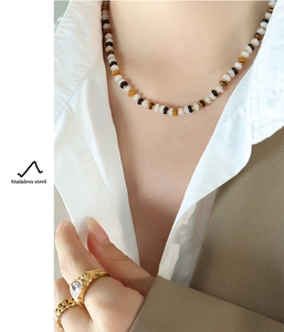 Detail of beaded necklace with natural white jade and black agate on stainless steel base