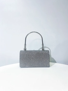 Detailed close-up of sparkling silver rhinestone evening clutch with elegant metal handle