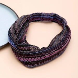Detail of twisted knitted headband featuring vibrant purple, blue, and black striped patterns