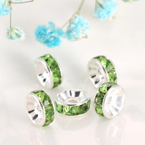 Macro view of green rhinestone spacer beads with silver base for DIY jewelry making