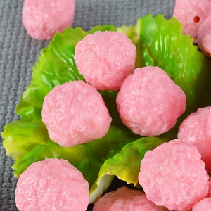 Realistic PVC food miniatures of pink shrimp balls on lettuce leaf for display