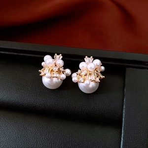 Detailed macro view of 18K gold plated pearl stud earrings with sparkling crystals
