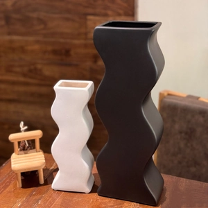 Vista dettagliata di vasi in ceramica a onde con finiture nero e bianco opaco