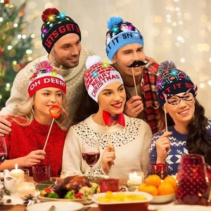 Erwachsene tragen festliche LED-Weihnachtsmützen mit Schneemann-Motiv in warmer Atmosphäre