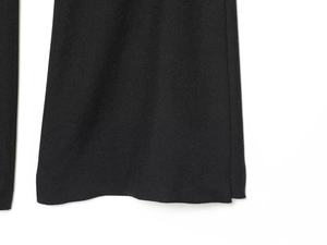 Detail shot of the hem and woven texture of black tailored trousers for women