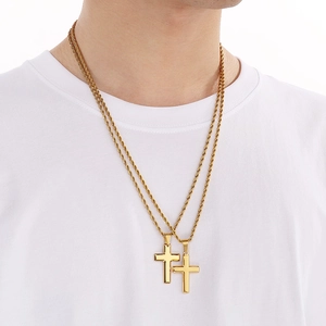 Close-up of double golden cross necklaces with rope chains on white shirt model