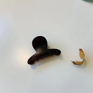Détail d'une petite pince à cheveux écaillée avec un mécanisme à ressort métallique