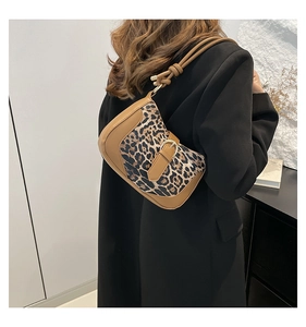 Detail showing the leopard print shoulder bag with knotted leather strap and metal buckle