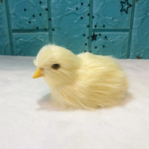 Detail of yellow plush chick toy with artificial fur on white fluffy surface