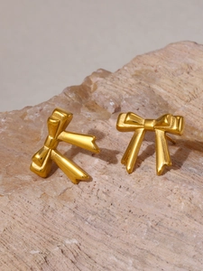 Gros plan de boucles d'oreilles nœud plaquées or sur une pierre minérale naturelle