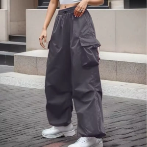 Deep grey wide-leg cargo pants with multi-pocket design and adjustable cuffs in street style