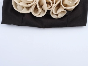 Dettaglio ravvicinato di fiori in rete 3D sull'orlo di un top a fascia nero sexy