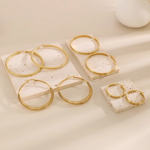 Set di quattro orecchini a cerchio dorati in acciaio inossidabile su pietre beige