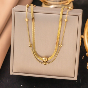 Double-layered gold-plated snake bone and beaded chain necklace with a large metal bead