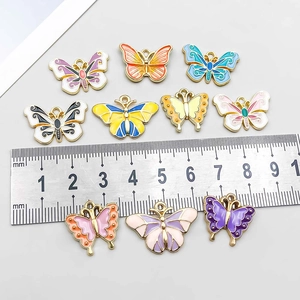 Assorted colorful gradient oil drip butterfly pendants with ruler for size reference