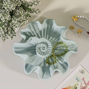 Macro view of spiral shell resin tray mold showing wavy texture and matte light blue finish