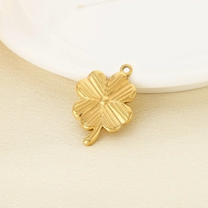 Macro shot of a golden four-leaf clover pendant with polished metallic finish