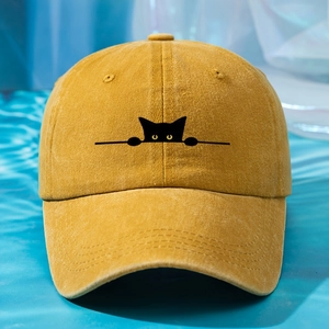 Close-up of a yellow washed cotton baseball cap featuring a black cat embroidery detail