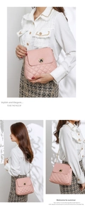 Detail of pink quilted crossbody bag featuring heart-shaped gold lock and chain strap