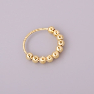 Golden anti-anxiety spinning bead ring on a purple background for stress relief