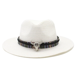 Dettaglio cappello di paglia bianco con fascia etnica e ornamento a testa di toro