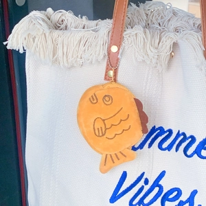 Plush Taiyaki fish purse with metal bead chain attached to a white canvas tote bag