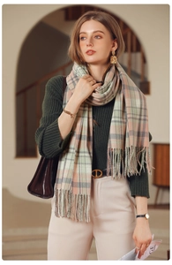 Detail of plaid scarf featuring pink and sage green checks with soft fringe edges