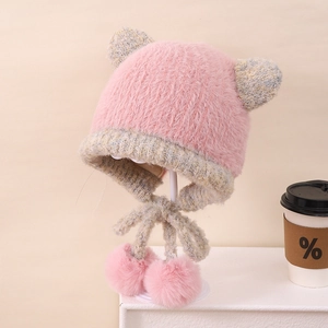 Dettaglio del cappello rosa peluche con paraorecchie e pompon soffici per bambini