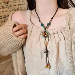 Détail du collier bohème avec perles en céramique colorées et longues franges en cuir