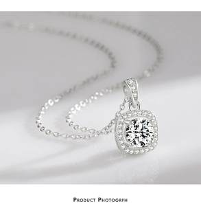 Macro shot of silver halo pendant with a round clear stone and sparkling pavé setting