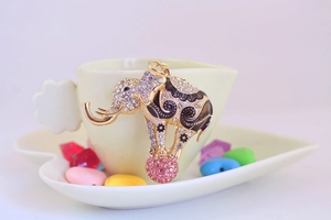 Detailed close-up of a golden elephant charm with sparkling rhinestones and pink crystal ball