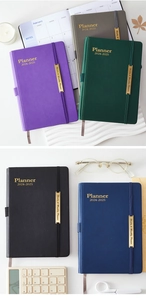 Close-up of 18-month faux leather planners in five colors with metal clasp and bookmarks