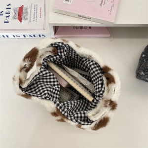 Vue détaillée du sac à main en peluche avec taches brunes et doublure à carreaux chic