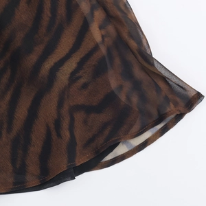 Détail du motif tigre sur l'ourlet d'une robe midi en maille translucide