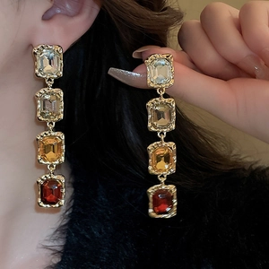 Vintage gold drop earrings with gradient square gemstones worn by a model in profile view