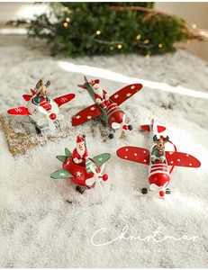 Metal Christmas airplane ornaments with Santa and reindeer on a snowy festive background