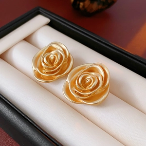 Macro detail of vintage gold rose stud earrings presented in a jewelry gift box