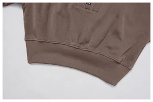 Detail of dark brown knitted hoodie with ribbed hem and high-quality metal zipper