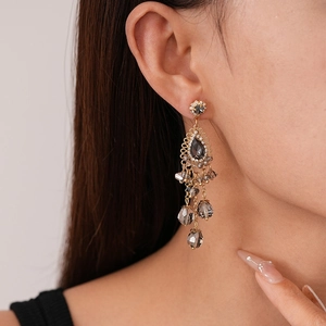 Détail de boucles d'oreilles vintage avec cristaux et pampilles de perles grises