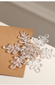Macro detail of transparent crystal beads and gold sequins on snowflake ornament