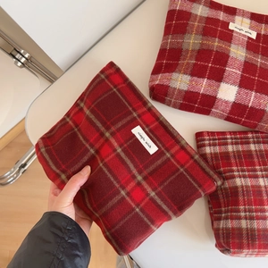 Détail du sac à cosmétiques en laine à carreaux rouges avec étiquette Simple Wish