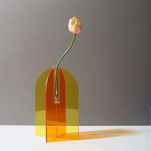 Detail of artistic orange acrylic vase with modern geometric arch design and glass test tube