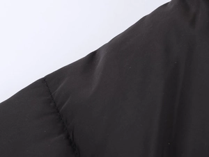 Close-up of black quilted puffer coat fabric with high-quality stitching detail