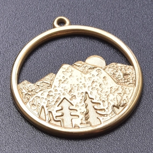 Macro view of 18k gold plated stainless steel pendant with mountain and sun relief