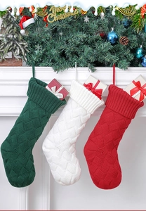 Detailed cable knit texture on festive red white and green Christmas stockings hanging