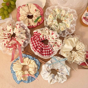Flat lay of diverse floral and lace scrunchies on a wooden tray in a cozy setting