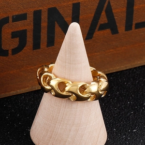Macro detail of golden cuban link chain ring displayed on a vintage wooden cone stand