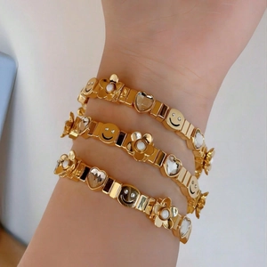 Women's gold stretch bracelet set featuring smiley faces, heart crystals and flowers