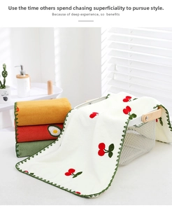 Detail of coral fleece hand towels with fruit embroidery and green wavy edge stitching