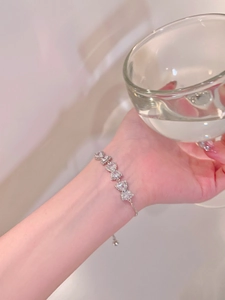 Close-up of a silver bow bracelet with zircons and an adjustable drawstring clasp